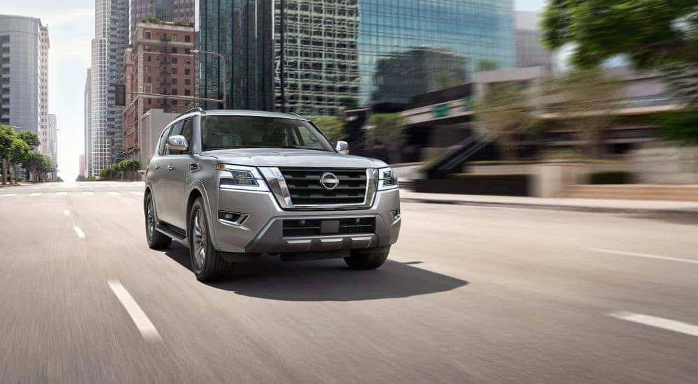 A silver 2023 Nissan Armada drives down an open city highway during the day