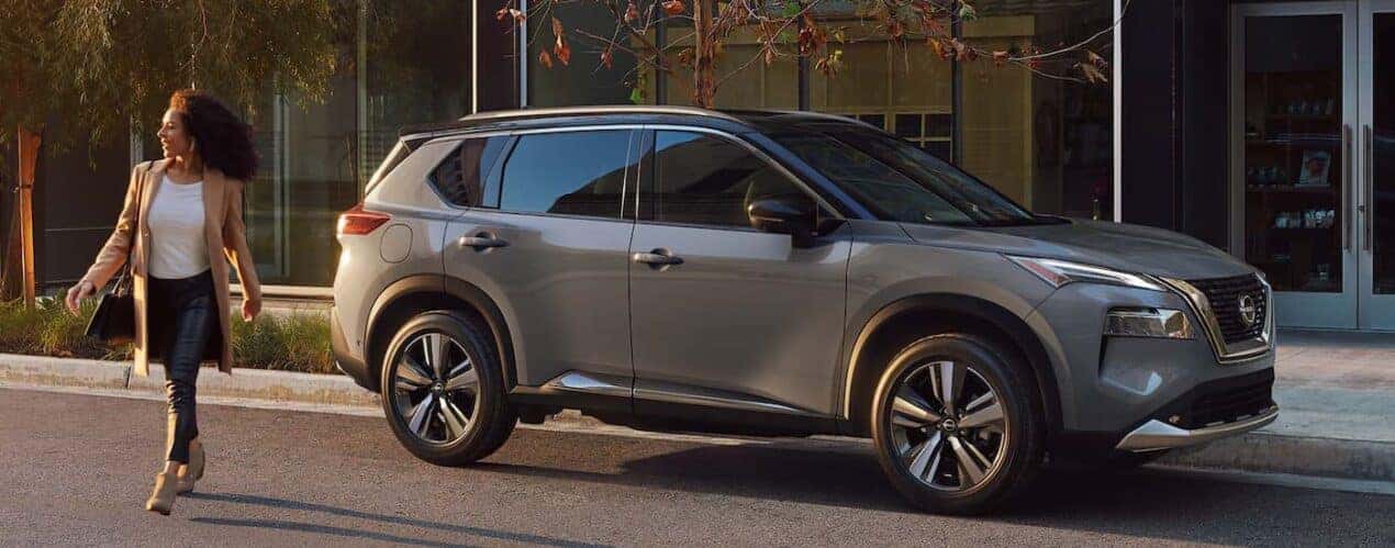 A grey 2023 Nissan Rogue is shown parked on the side of a city street.
