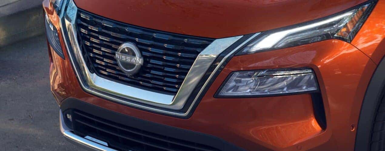 A close up of the front of an orange 2023 Nissan Rogue is shown during a 2023 Nissan Rogue vs 2023 Toyota RAV4 comparison.