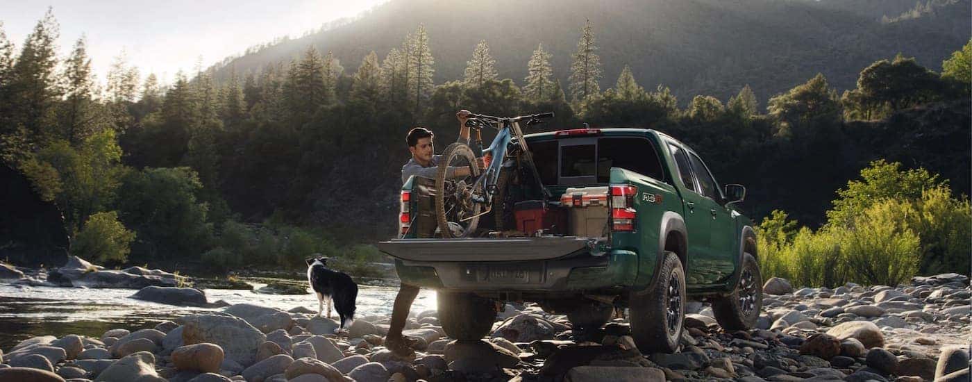 A green 2023 Nissan Frontier is shown from the rear.