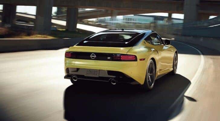 A yellow 2023 Nissan Z is shown from the rear at an angle after leaving a Portland Nissan dealer.