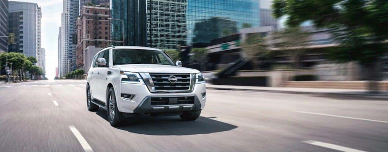 A white 2023 Nissan Armada is shown from the front at an angle on a city street.