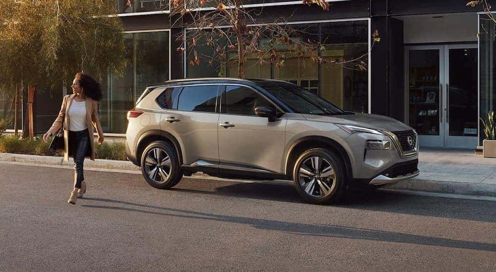 A silver 2023 Nissan Rogue Platinum is shown parked near a Gallatin Nissan dealership.