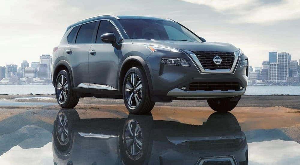 A silver 2023 Nissan Rogue is shown parked near a puddle.