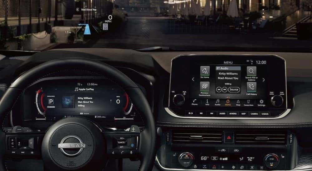 The black dash of a 2023 Nissan Rogue for sale is shown.
