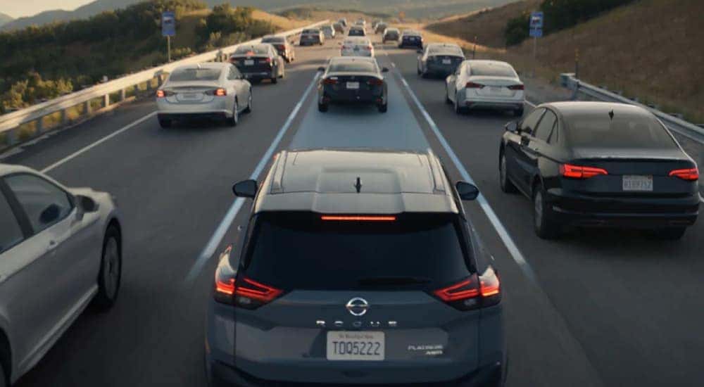 A grey 2021 Nissan Rogue Sport is shown driving from behind.