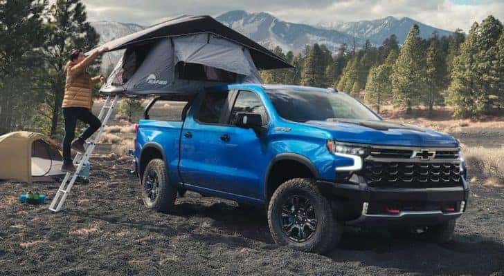 A blue 2022 Chevy Silverado 1500 ZR2 is shown at a campsite.
