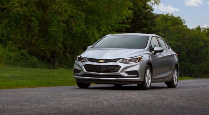 A silver 2018 Chevy Cruze is shown on a wooded road after leaving a used Chevrolet dealer.