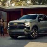 A silver 2023 Chevy Silverado 1500 Z71 is shown parked in front of a modern house.