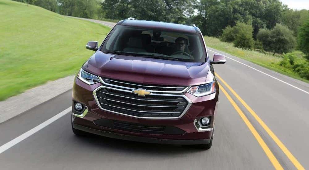A purple 2018 Chevy Traverse is shown from the front driving on an open road.