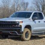 A grey 2020 Chevy Silverado 1500 Trail Boss is shown from the front at an angle after leaving a dealer that has a Chevy Silverado for sale.