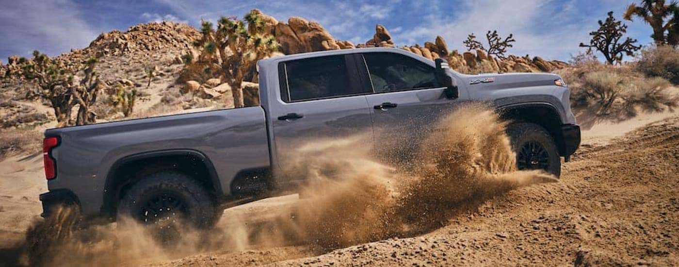 A grey 2024 Chevy Silverado 2500 ZR2 is shown from the side after leaving a dealer that has Chevy trucks for sale.