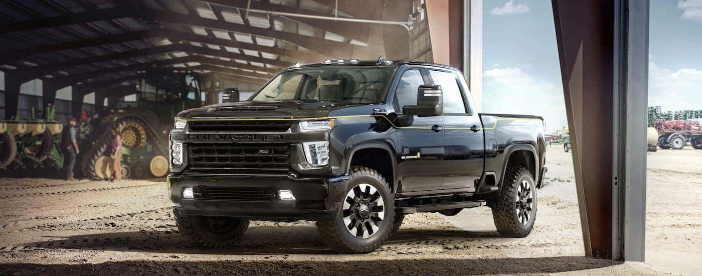 A black 2021 Chevy Silverado 2500 HD Carhartt Edition is shown from the front at an angle after leaving a dealer that has a used Chevy Silverado for sale.