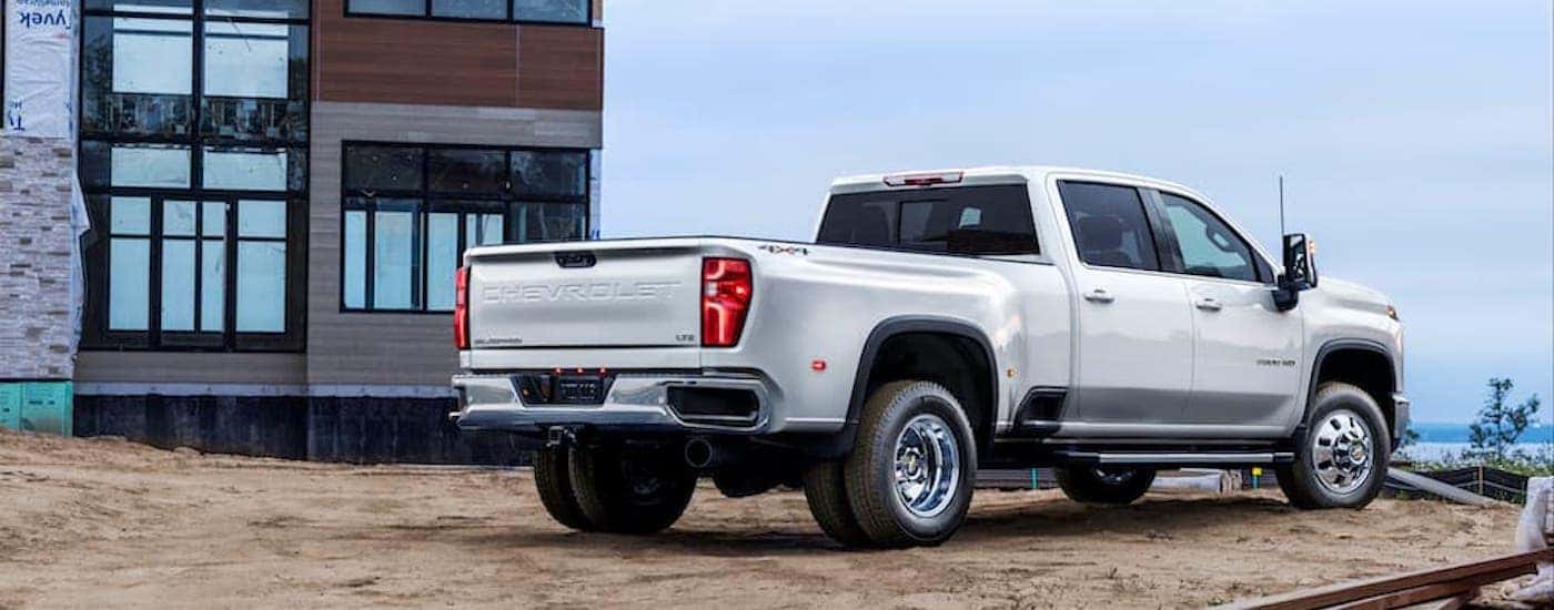 A white 2024 Chevy Silverado 3500 HD is shown from the rear at an angle after leaving a dealer that has heavy duty trucks for sale.