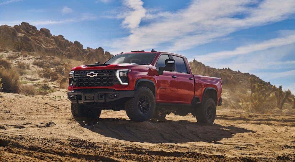 A red 2024 Chevy Silverado 2500 ZR2 Bison is shown from the front at an angle after leaving a dealer that has heavy duty trucks for sale.