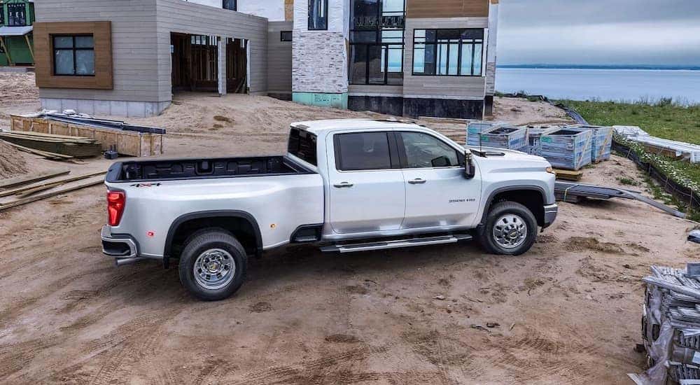 A white 2024 Chevy Silverado 3500 HD is shown from the side on a jobsite.