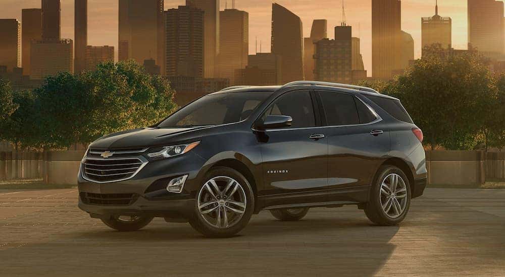 A black 2020 Chevy Equinox is shown parked near a city.
