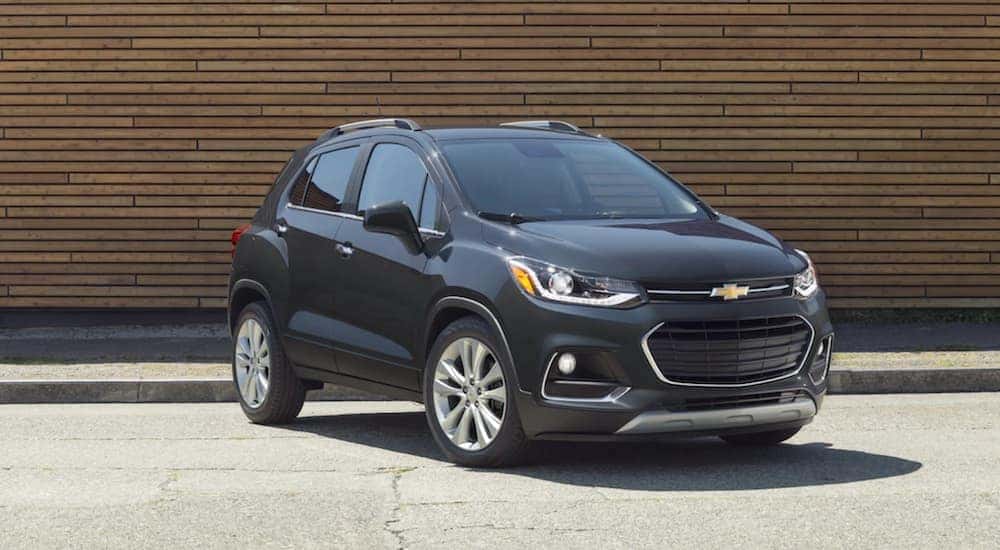 A black 2020 Chevy Trax is shown parked near a city curb.