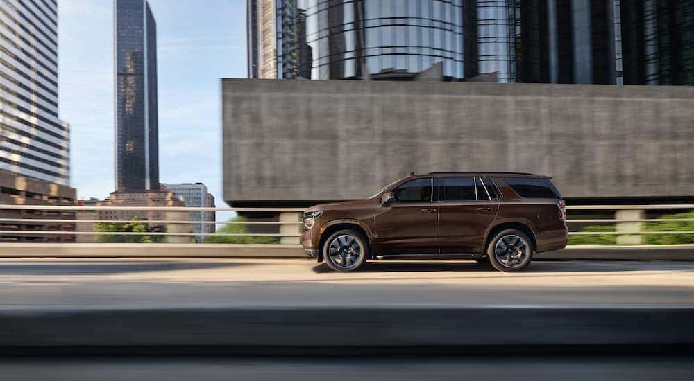 A brown 2022 Chevy Tahoe is shown driving on a highway.
