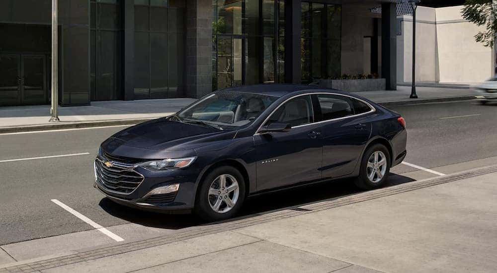 A blue 2023 Chevy Malibu is shown parked near a used Chevy dealer near Arcadia.