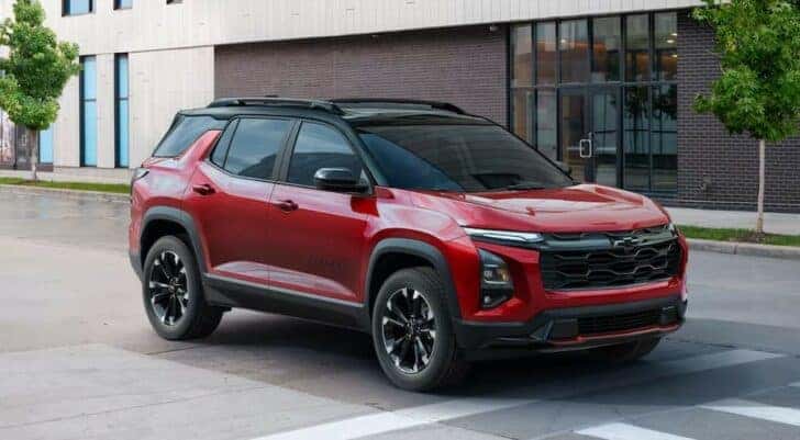 A red 2025 Chevy Equinox RS is shown stopped near a crosswalk.
