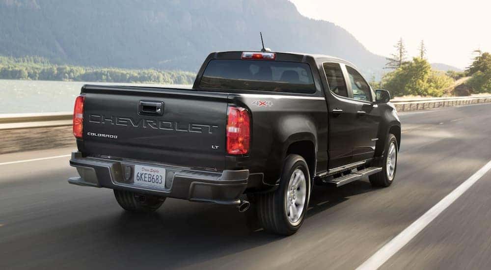 Rear view of a black 2022 Chevy Colorado LT driving on the highway.
