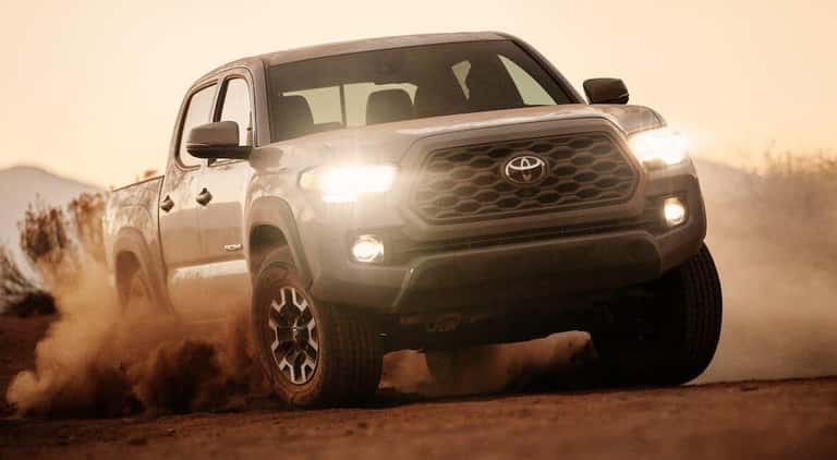 A grey 2020 Toyota Tacoma driving off-road through a desert.