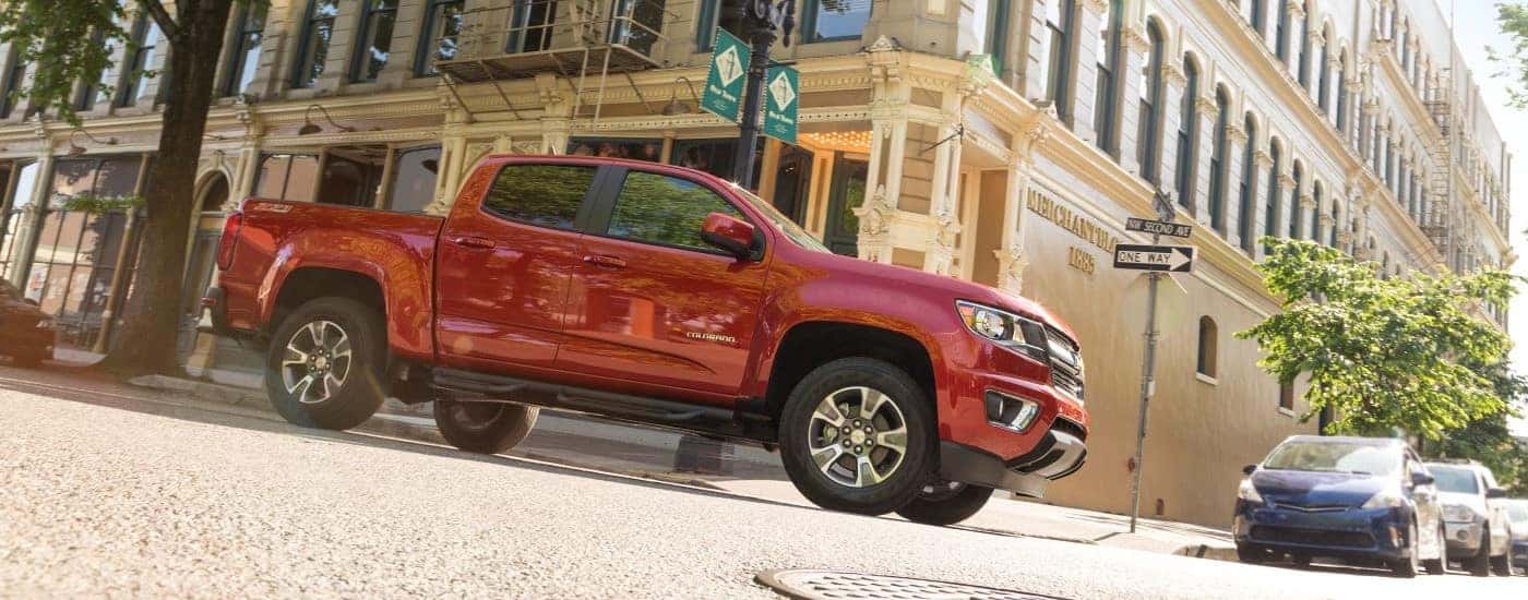 A red 2015 Chevy Colorado Z71 is shown driving on a city street.