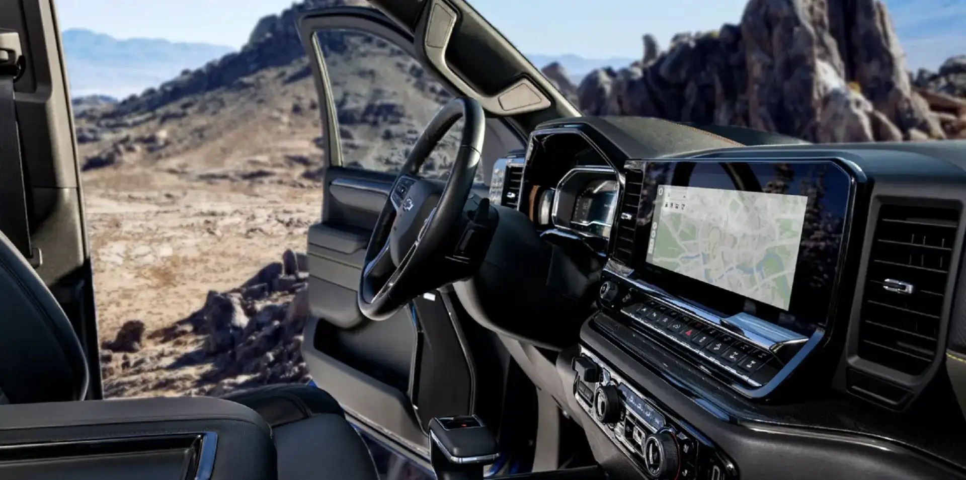 Interior view of a Chevy Silverado’s steering wheel, dashboard, and touch-screen navigation display