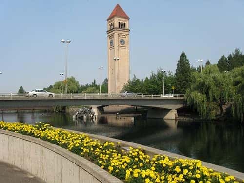 Standing on sidewalk beside the spokane river looking at great northern clock tower