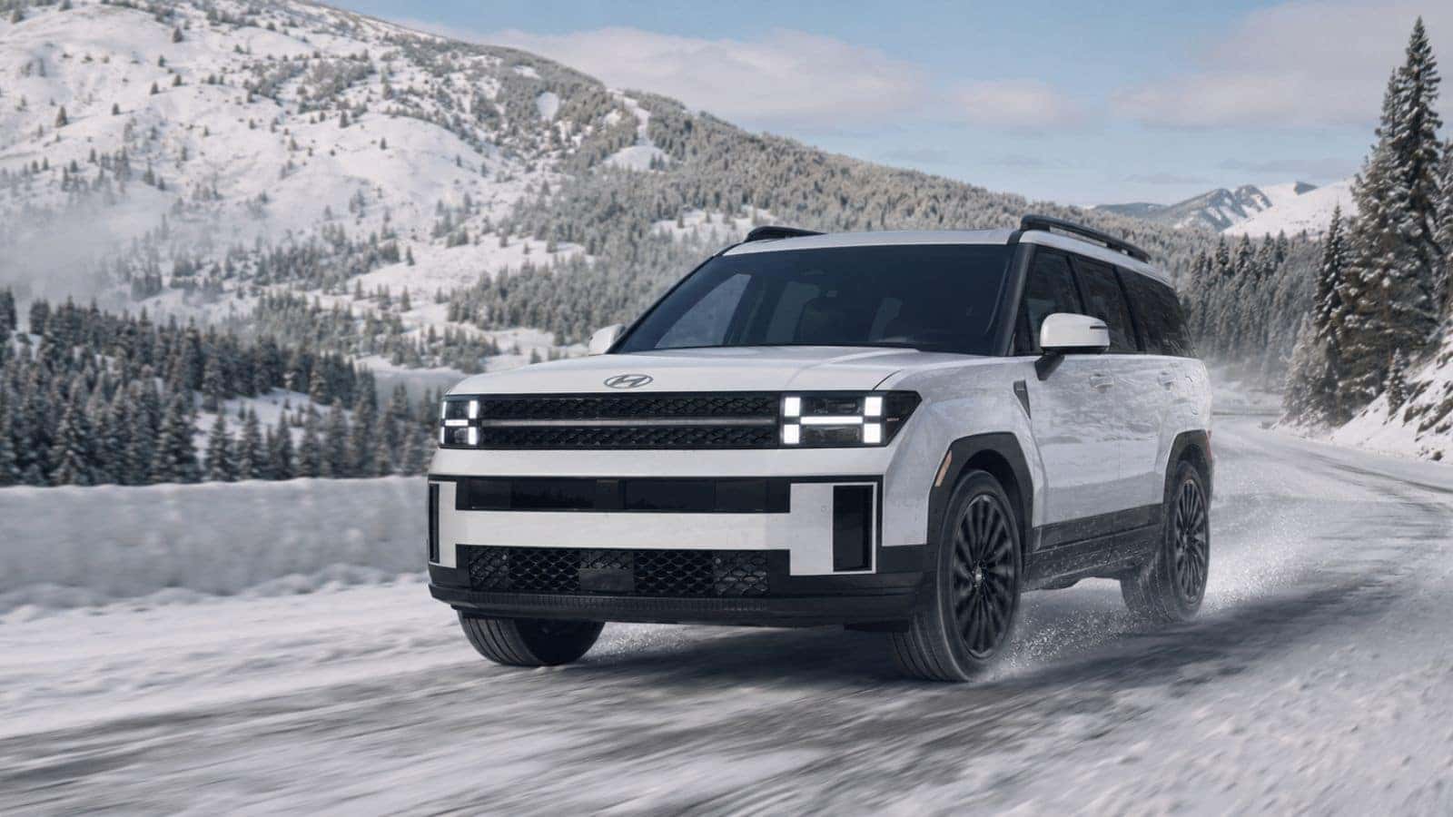 Hyundai SUV driving through snow on an Inland Northwest mountain road