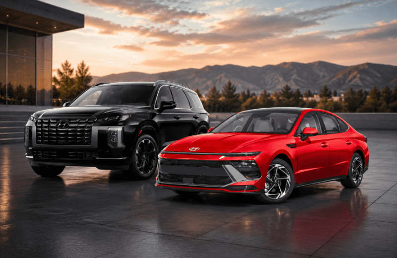 New Hyundai vehicles, including a red sedan and black SUV, displayed against a scenic mountain backdrop.