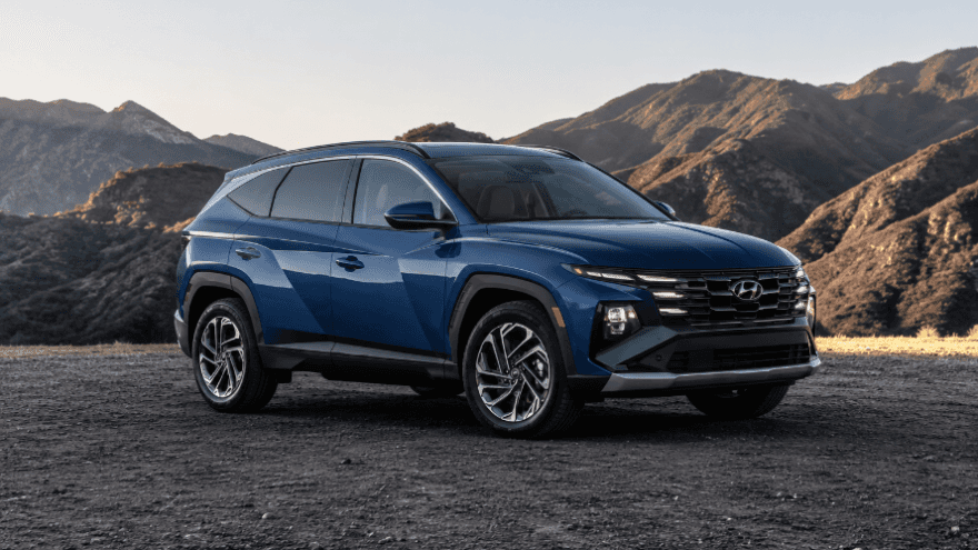 Blue Hyundai Tucson SUV on a scenic mountain road.