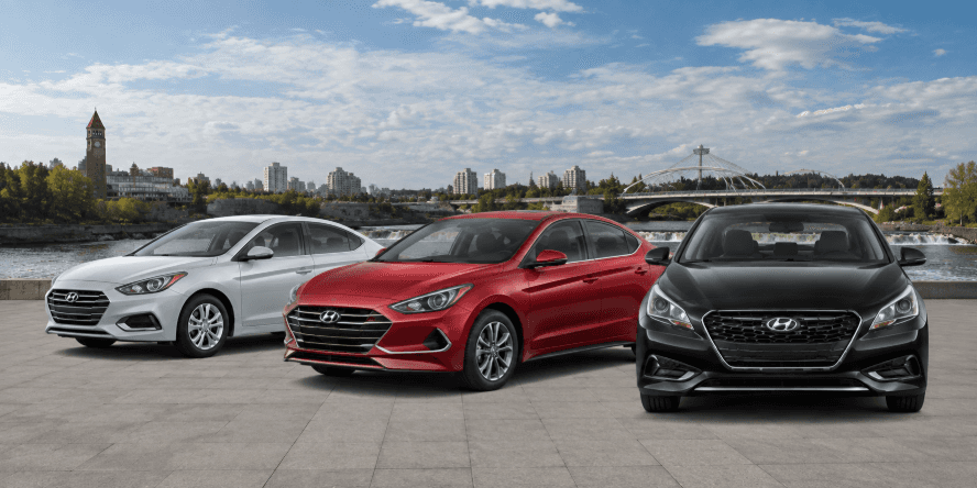 Three Hyundai sedans in black, red, and silver parked on a scenic riverfront