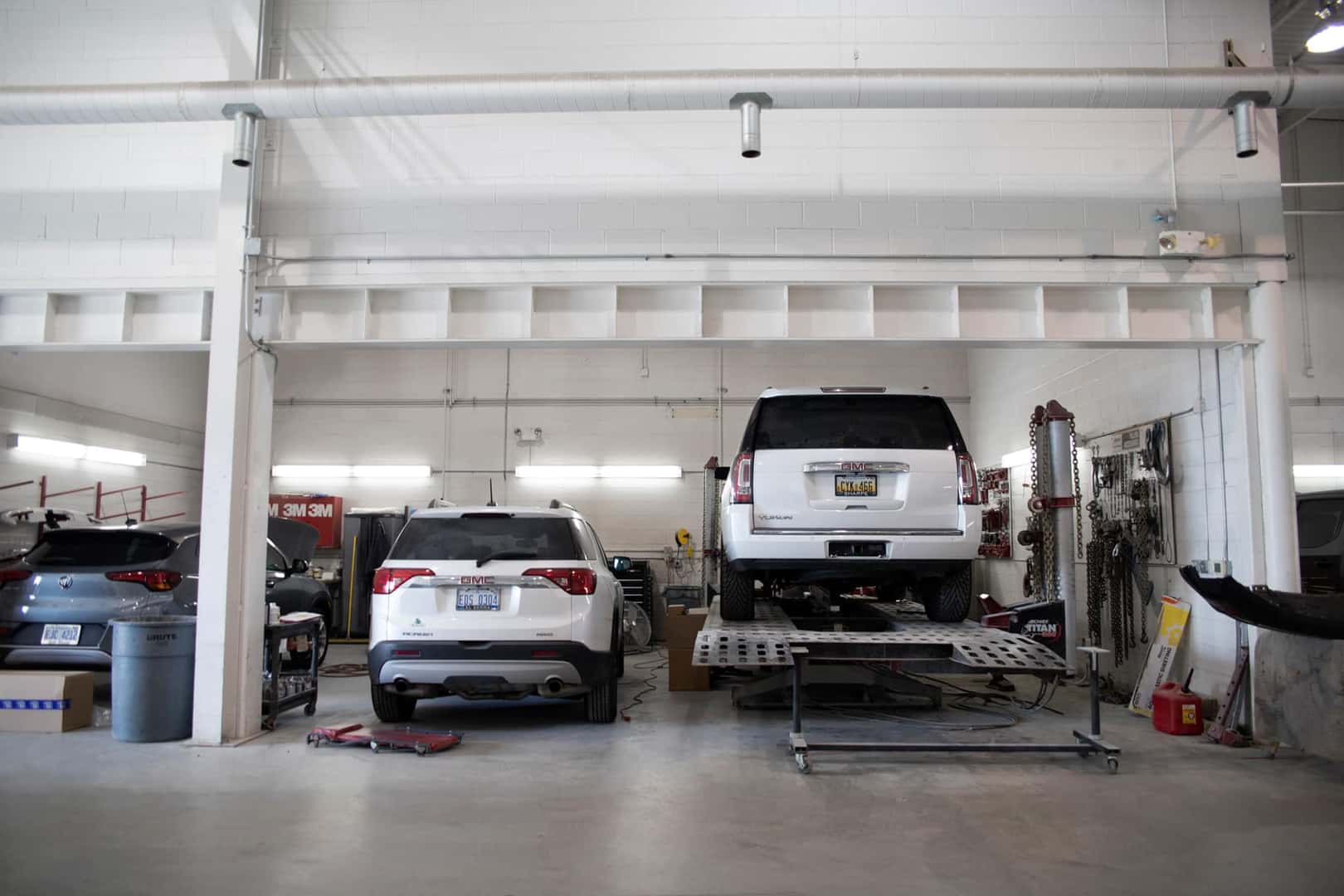 2 Cars on lifts in body shop
