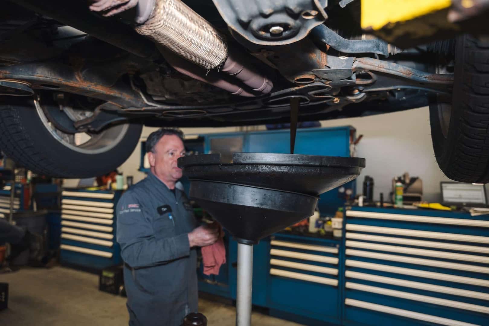 A closeup shot of a hand's man pouring oil in the car's engine