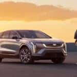 2025 Cadillac OPTIQ parked in an open area with a man walking towards the SUV