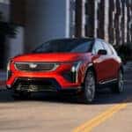 A red 2026 Cadillac OPTIQ on the road
