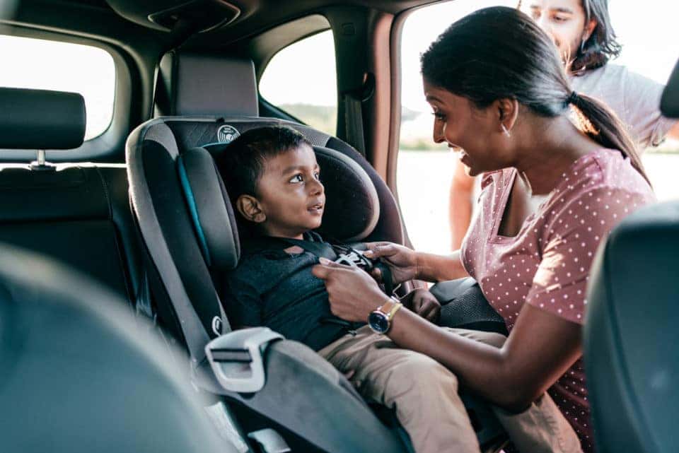 Child Being Buckled Into Car Seat